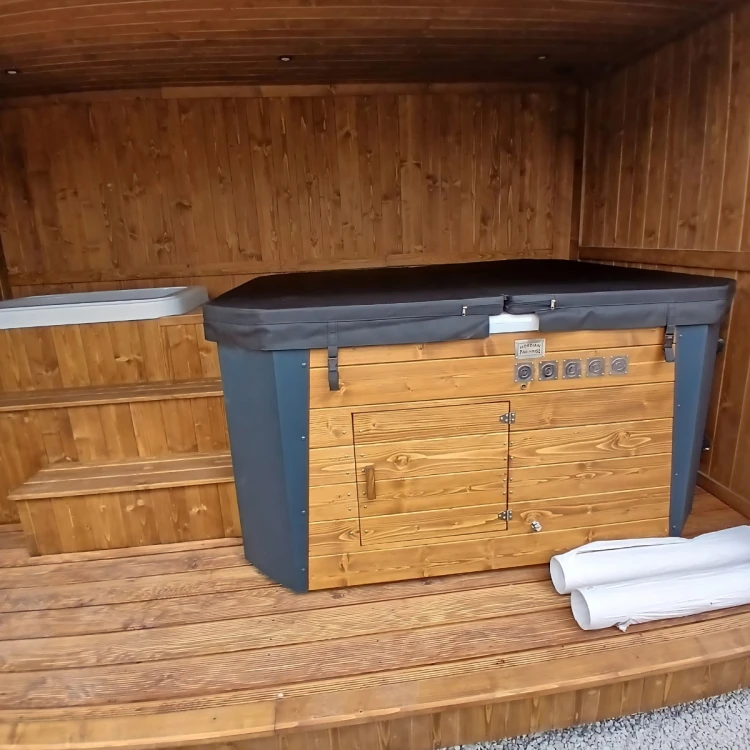 Przemyślana strefa wellness w ogrodzie – drewniany moduł saunowy z dużym oknem widokowym, oświetleniem LED oraz zintegrowanym jacuzzi pod dachem